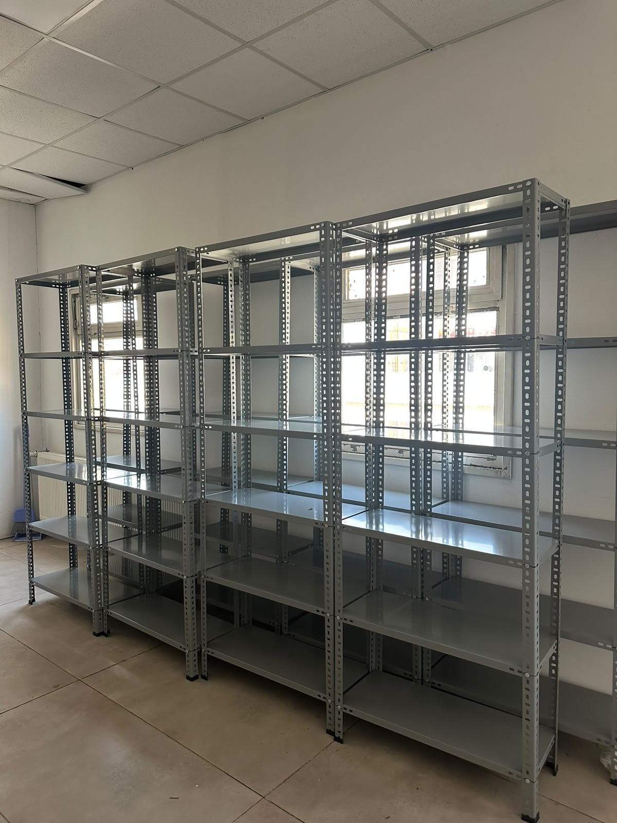 Aydınlık iç mekânda sıralı metal çelik raf üniteleri